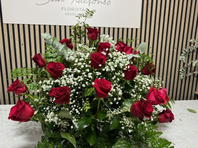 Centro delante del mostrador de la floristería San Ildefonso con con rosas rojas
