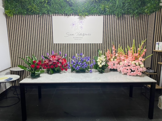 Centros delante del mostrador de la floristería San Ildefonso en tonos varios