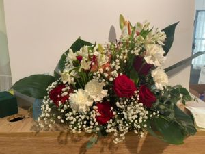 Jardinera delante del mostrador de la floristería San Ildefonso con rosas rojas