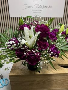 Arreglo delante del mostrador de la floristería San Ildefonso en tonos morados con lírios