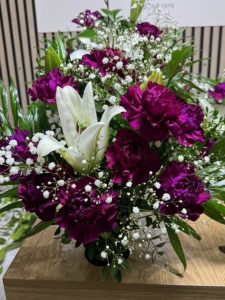 Arreglo delante del mostrador de la floristería San Ildefonso en tonos morados