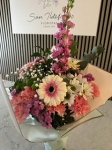 Ramo delante del mostrador de la floristería San Ildefonso en tonos blancos y rosas