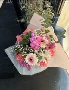 Ramo delante del mostrador de la floristería San Ildefonso en tonos blancos y rosas