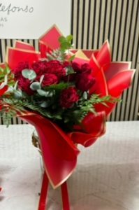 Ramo delante del mostrador de la floristería San Ildefonso en tonos rojos