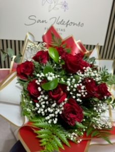 Ramo delante del mostrador de la floristería San Ildefonso en tonos rojos