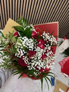 Ramo delante del mostrador de la floristería San Ildefonso en tonos rojos