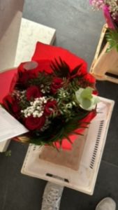 Ramo delante del mostrador de la floristería San Ildefonso en tonos rojos