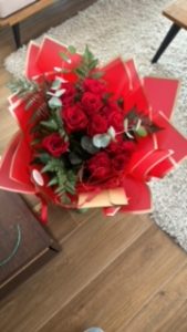 Ramo delante del mostrador de la floristería San Ildefonso en tonos blancos y rojos