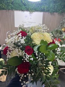 Ramo delante del mostrador de la floristería San Ildefonso en tonos blancos y rojos