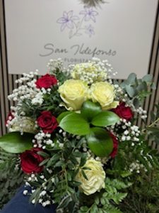 Ramo delante del mostrador de la floristería San Ildefonso en tonos blancos y rojos