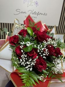 Ramo delante del mostrador de la floristería San Ildefonso en en tonos rojos