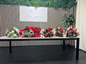 Ramo delante del mostrador de la floristería San Ildefonso en en tonos rojos