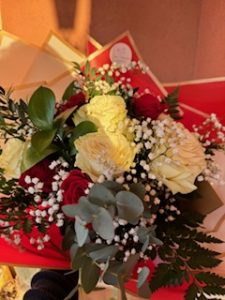 Ramo delante del mostrador de la floristería San Ildefonso en en tonos rojos