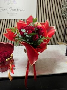 Ramo delante del mostrador de la floristería San Ildefonso en en tonos rojos