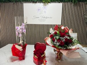 Ramo delante del mostrador de la floristería San Ildefonso en en tonos rojos