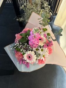 Ramo delante del mostrador de la floristería San Ildefonso en tonos rosas