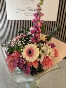 Ramo delante del mostrador de la floristería San Ildefonso en tonos rosas